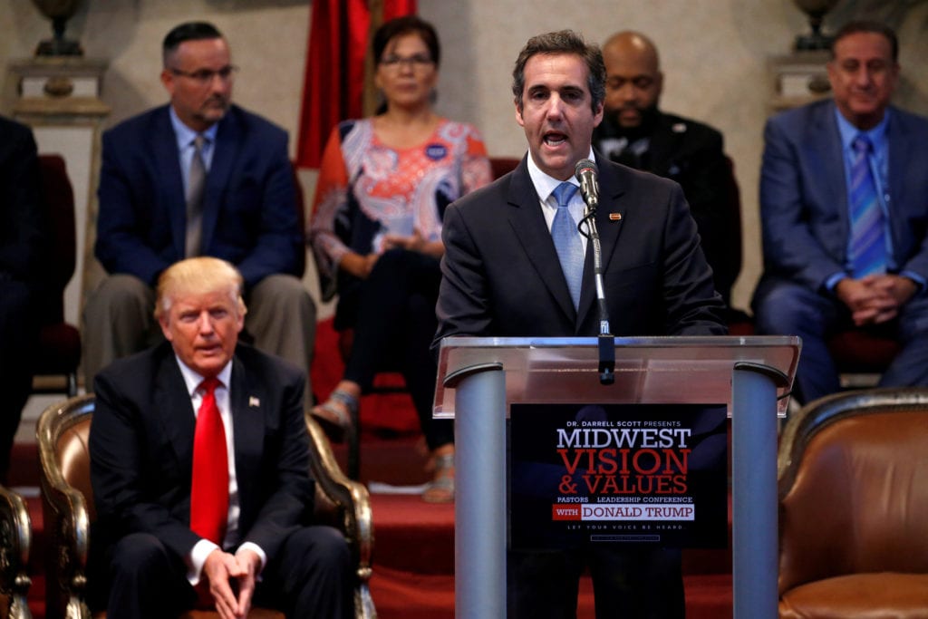 Donald Trump listening as his then personal attorney Michael Cohen delivers remarks on his behalf in September 21, 2016